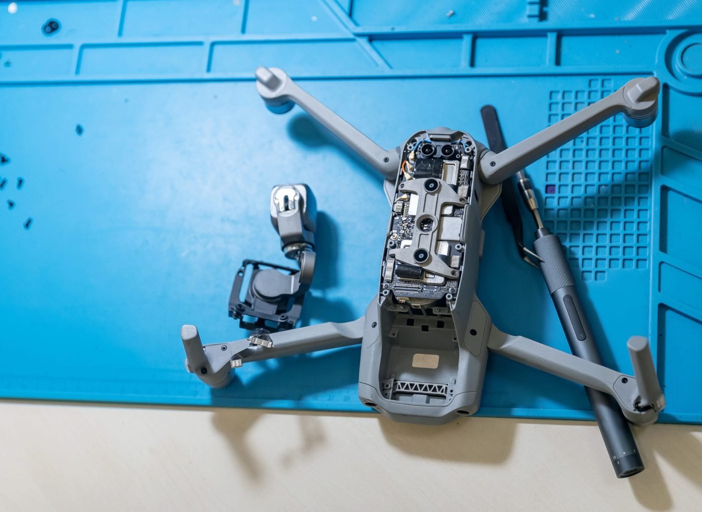 Professional repair of RC drones and radio controlled cars, robots.Broken quadrocopter lies on desktop, top view.